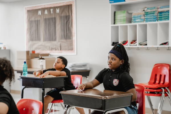 PACE Academy students sit at desks in a classroom engaged with something out of the frame.